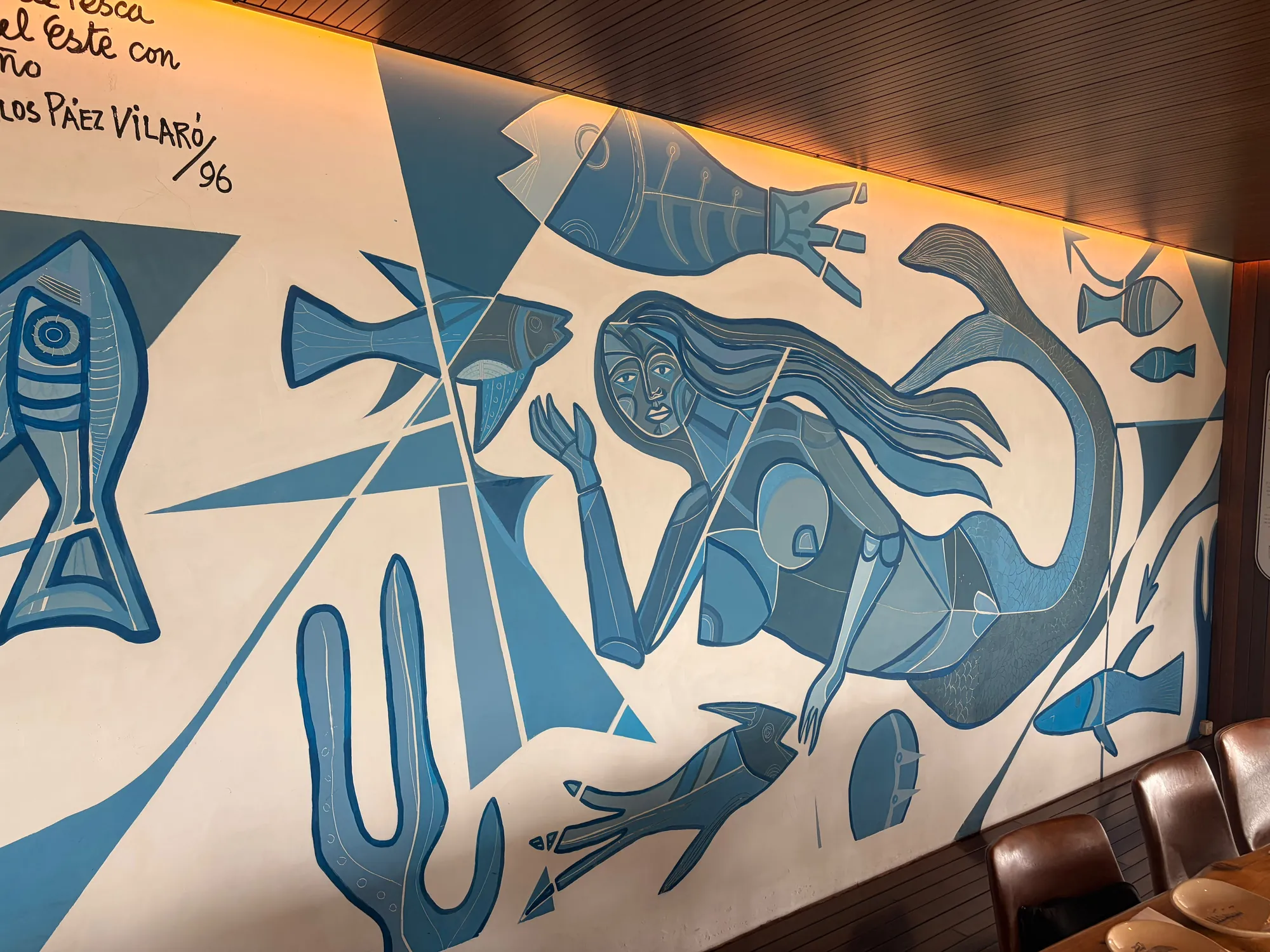 Mural de Carlos Páez Vilaró en el salón: una sirena entre peces en tonos de azul, con su dedicatoria al Club de Pesca